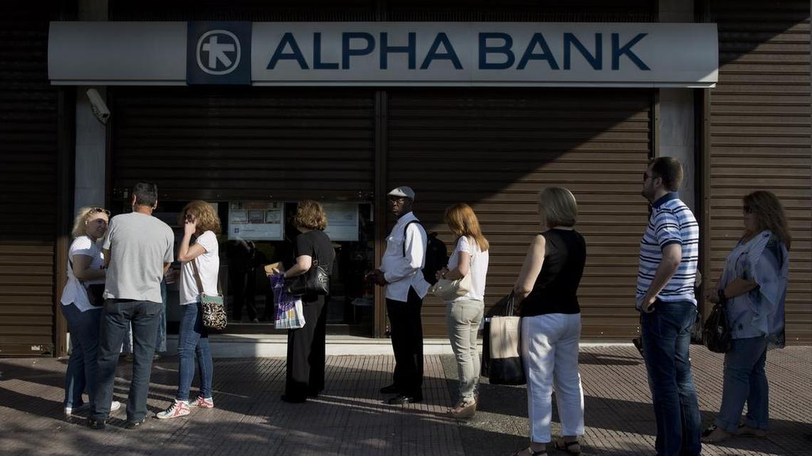 People line up outside an Alpha Bank branch in Athens in June to use its ATM. The European Central Bank says Saturday, Oct. 31, 2015, Greece’s battered banks need 14.4 billion euros (US dollar 15.8 billion) in fresh money to get back on their feet and resume normal business.
