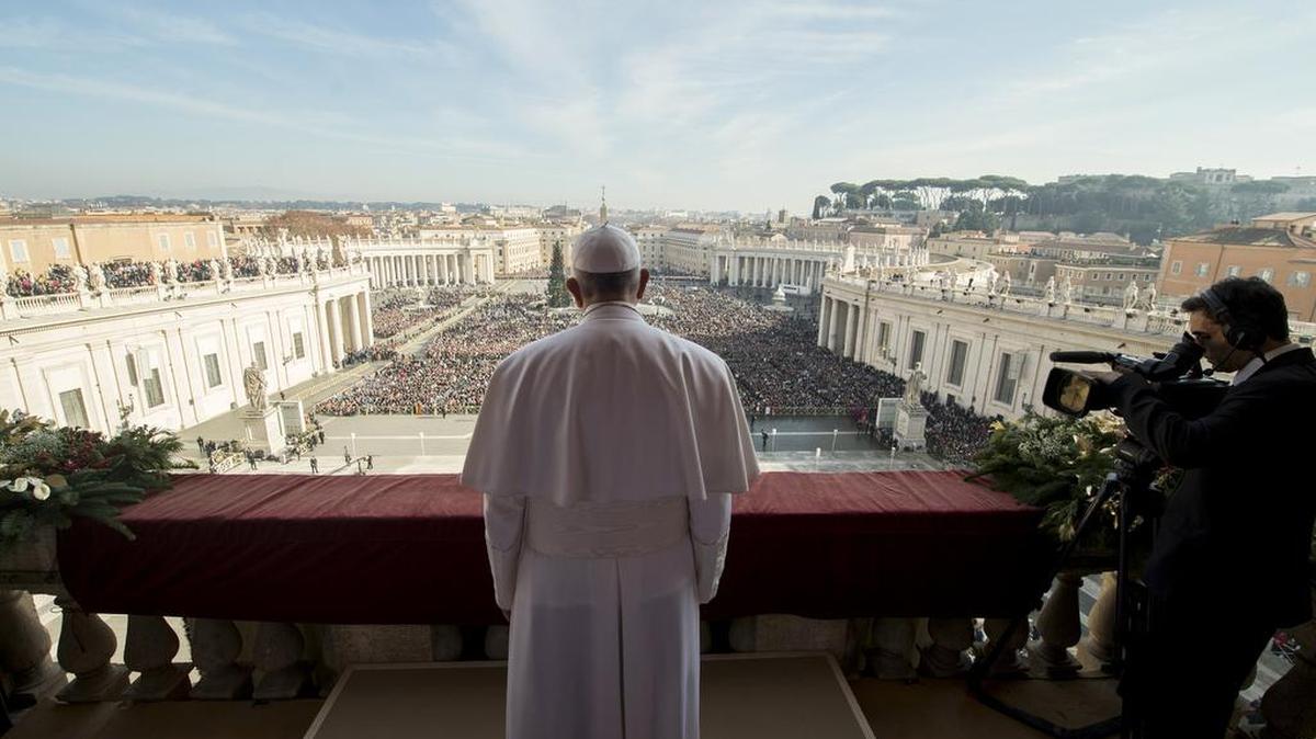 Pope Francis delivers his “Urbi et Orbi” (“To the city and to the world”) blessing from the central balcony of St. Peter’s Basilica at the Vatican on Friday, Dec. 25, 2015. Pope Francis is praying that recent U.N.-backed peace agreements for Syria and Libya will quickly end the suffering of their people while praising the generosity of those countries that have taken their refugees in.