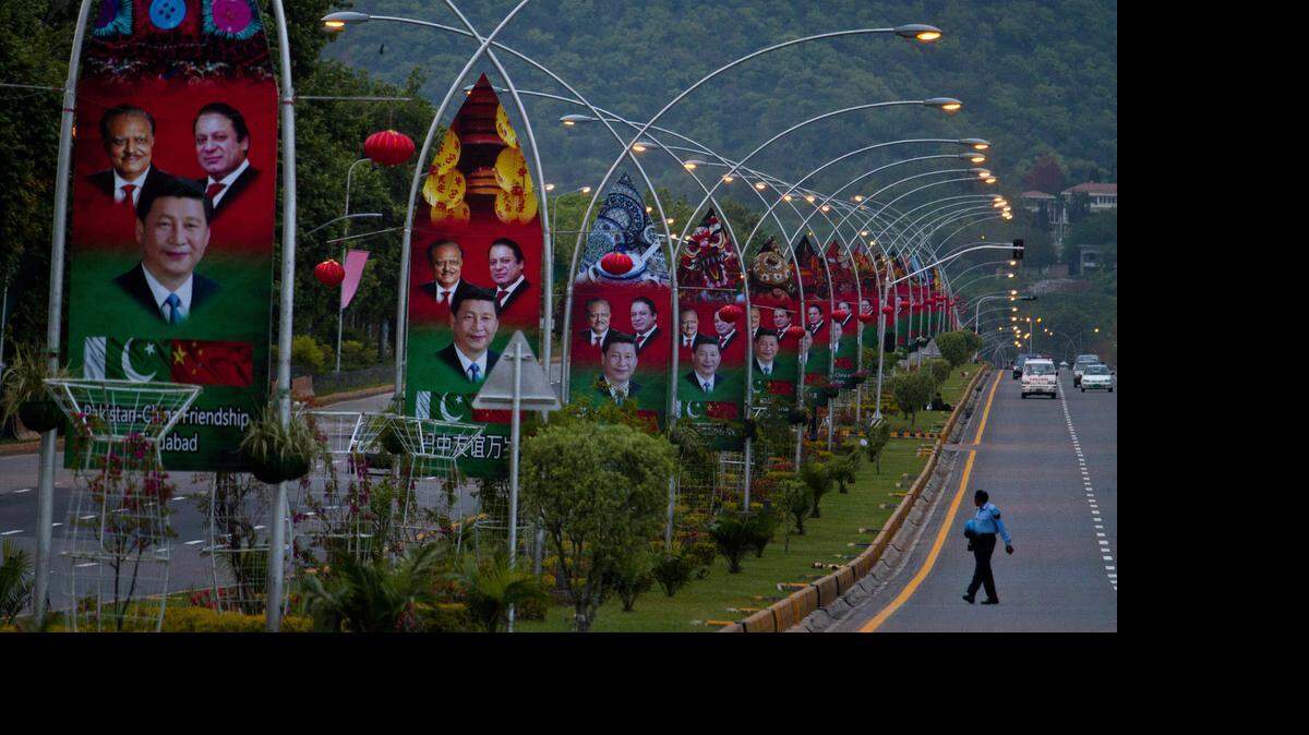 
A Pakistani police officer walks pasts billboards showing pictures of Chinese President Xi Jinping, center, with Pakistan's President Mamnoon Hussain, left, and Prime Minister Nawaz Sharif welcoming Xi Jingping to Islamabad, Pakistan, Sunday, April 19, 2015. 
