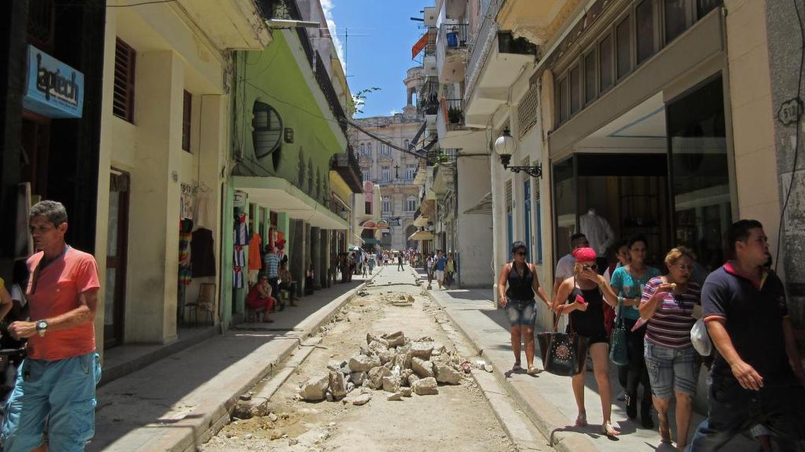 Pedestrians walk on a narrow street in Old Havana, Cuba, on May 17, 2015.