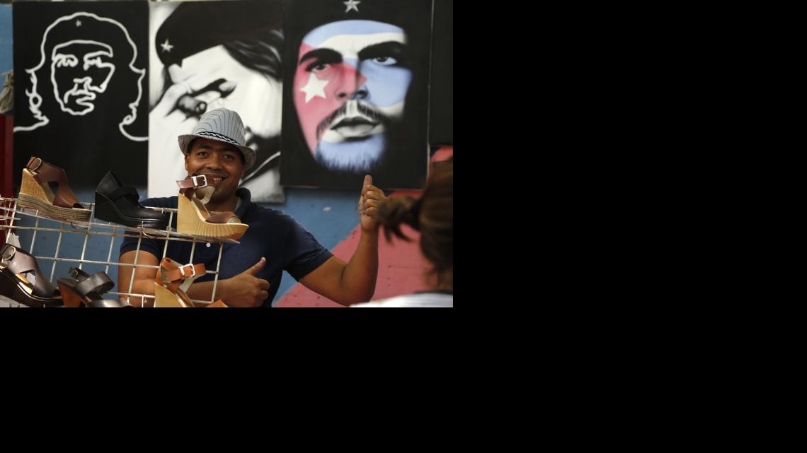 
A vendor gives a thumbs up to the camera as he sells shoes and paintings of Cuba's revolutionary hero Ernesto "Che" Guevara in Havana, Cuba, Tuesday, April 14, 2015. President Barack Obama will remove Cuba from the list of state sponsors of terrorism, the White House announced Tuesday, a key step in his bid to normalize relations between the two countries.
