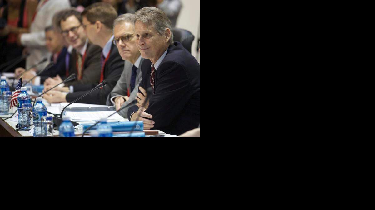 
Deputy Assistant Secretary at the U.S. State Department's Bureau of Western Hemisphere Affairs Edward Alex Lee, right, and members of a U.S. delegation, sit across from Cuban delegates as they begin negotiations, in Havana, Cuba, Wednesday, Jan. 21, 2015. The highest-level U.S. delegation to Cuba in decades kicked off two days of negotiations Wednesday after grand promises by President Barack Obama about change on the island and a somber warning from Cuba to abandon hopes of reforming the communist government. 
