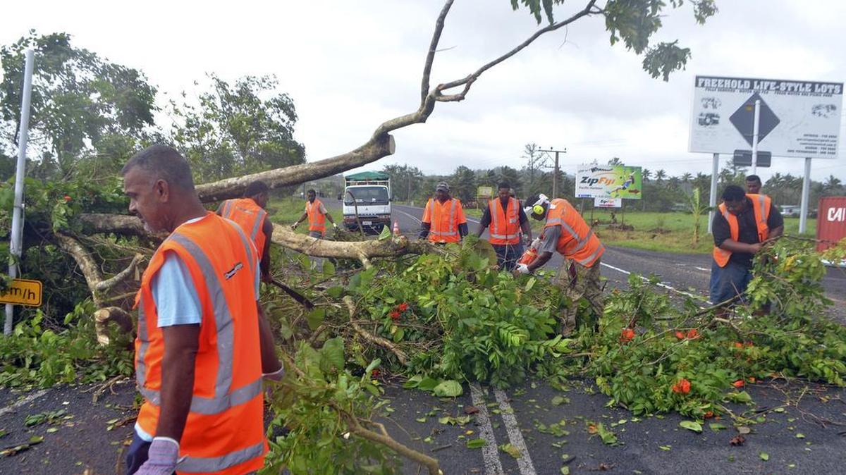 Road workers remove a fallen tree blocking a road near Lami, Fiji, on Sunday, Feb. 21, 2016, after Cyclone Winston ripped through the country.