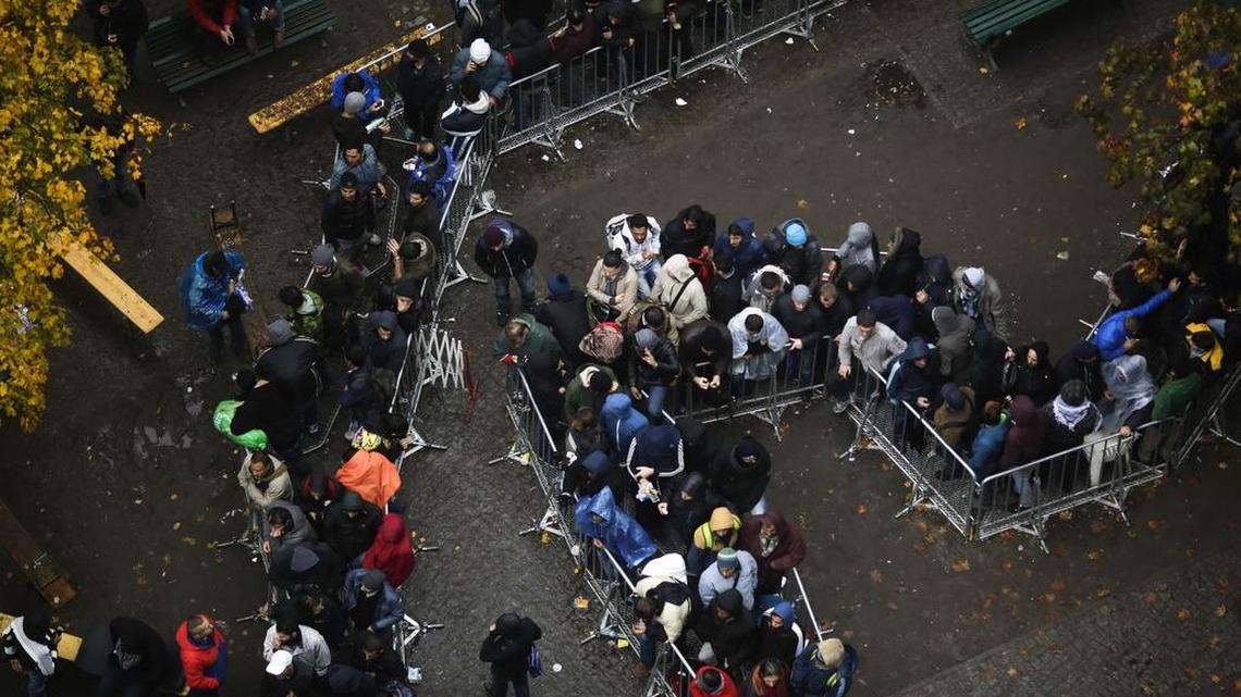 Migrants wait for their registration outside the main office of the State Office of Health and Welfare in Berlin, Germany. The influx of refugees from Syria and elsewhere has prompted postings on Facebook that many feel violates German laws against hate speech.