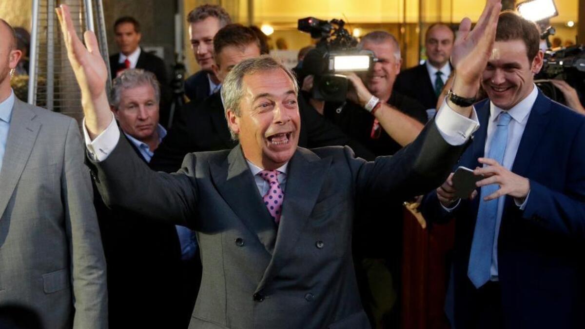 Nigel Farage, the leader of the UK Independence Party, celebrates and poses for photographers as he leaves a "Leave.EU" organization party for the British European Union membership referendum in London on Friday.