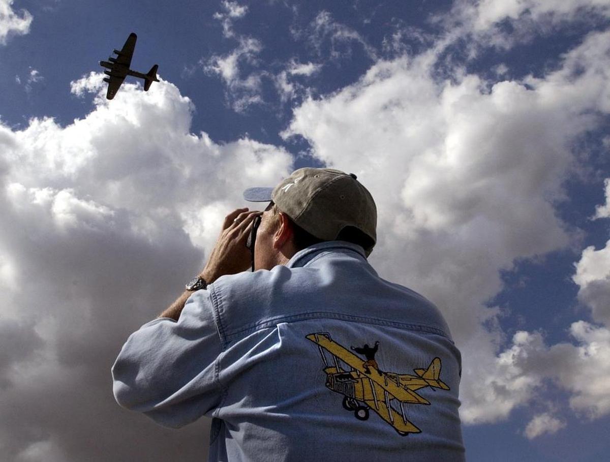 A fan snaps a photo of a Boeing B-17 Flying Fortress. The World War II bomber will be featured at this weekend's Olympic Air Show in Tumwater.