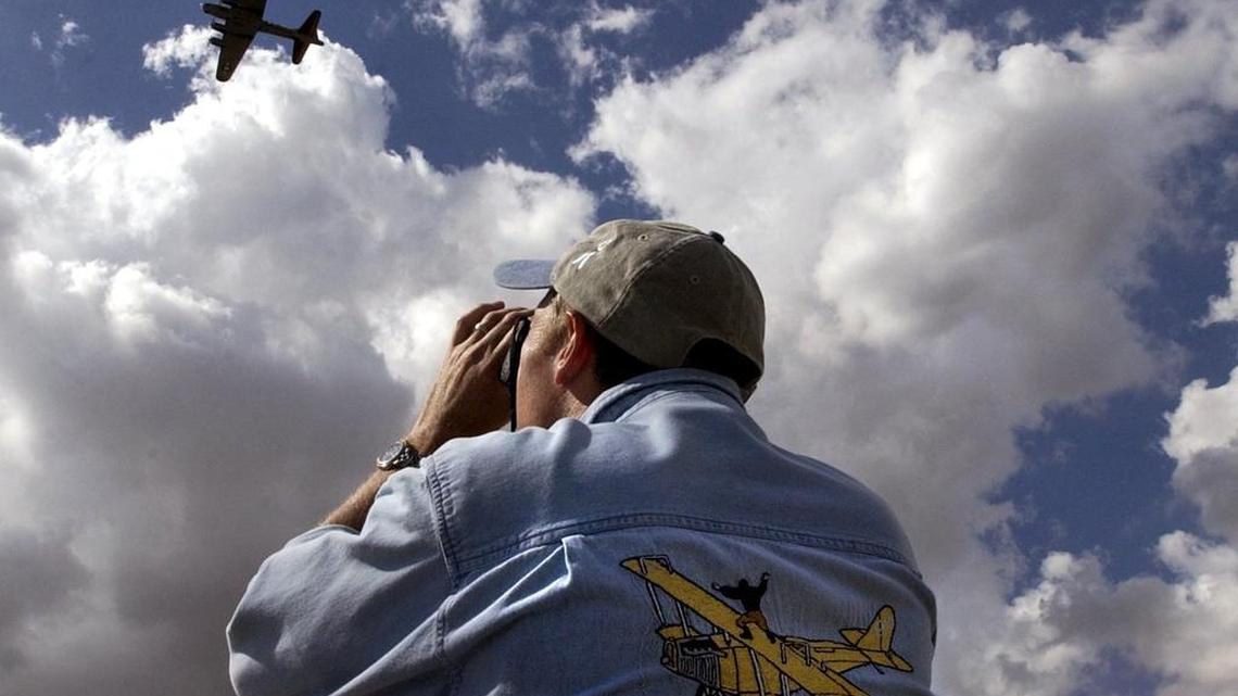 A fan snaps a photo of a Boeing B-17 Flying Fortress.