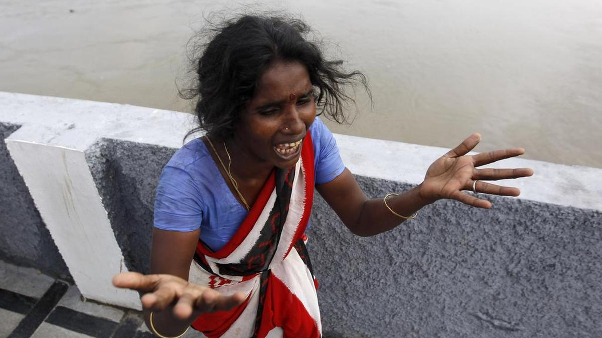 A woman cries after seeing the corpse of her son floating in the Adyar River after he was washed away by floodwaters in Chennai, in the southern Indian state of Tamil Nadu on Friday. The relentless rains that lashed the state for three days eased Friday, but the misery of tens of thousands of people was far from over, with large parts of the main city still underwater along with the region's biggest airport.