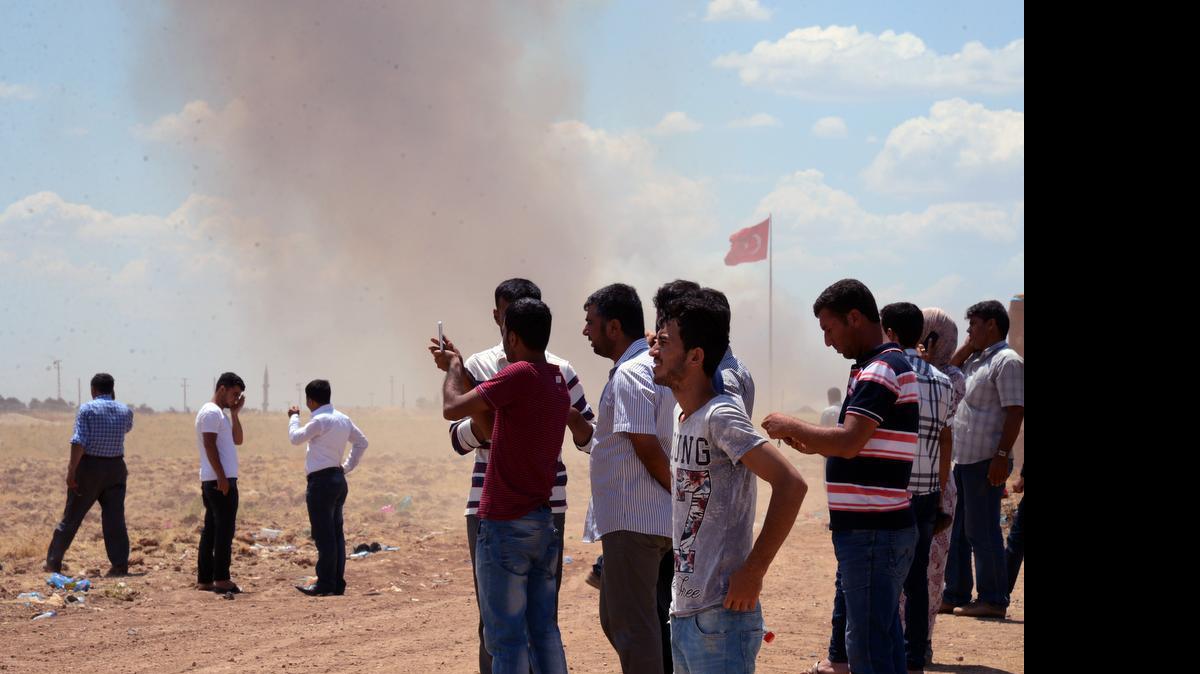 
Turkish Kurds watch the situation in Kobani, Syria, from the Turkish side of the border in Suruc, Turkey, Friday, June 26, 2015 as smoke rises in the area. Defense Secretary Ash Carter said Kurdish fighters from the YPG militia are identifying bombing targets for U.S.-led airstrikes.

