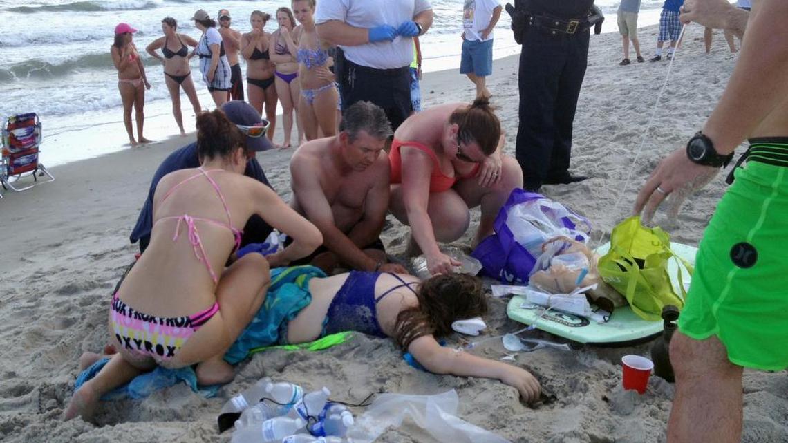 Emergency responders assist a teenage girl at the scene of a shark attack in Oak Island, N.C., in June. Experts say 2015 saw a record-setting 98 unprovoked shark attacks worldwide, including 59 in the United States.