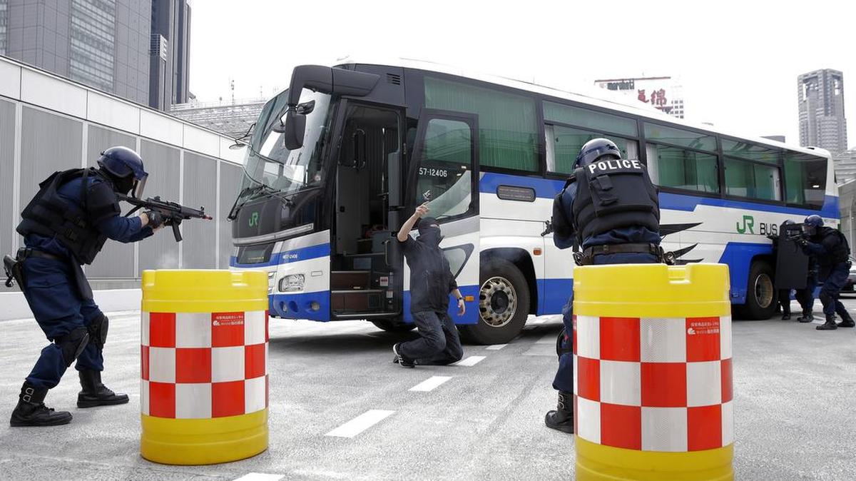 Members of the Emergency Response Team of Japan's Metropolitan Police Department simulate a bus hijacking and hostage crisis during a drill at a bus terminal in Tokyo on March 30.