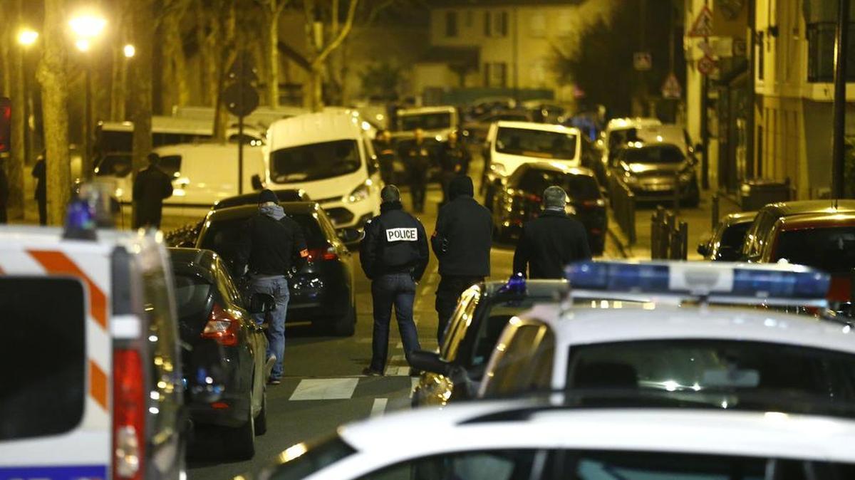 Police officers block a street in Argenteuil, northwest of Paris, late Thursday March 24, 2016 as security forces locked down the area during a major search, France's interior minister said.