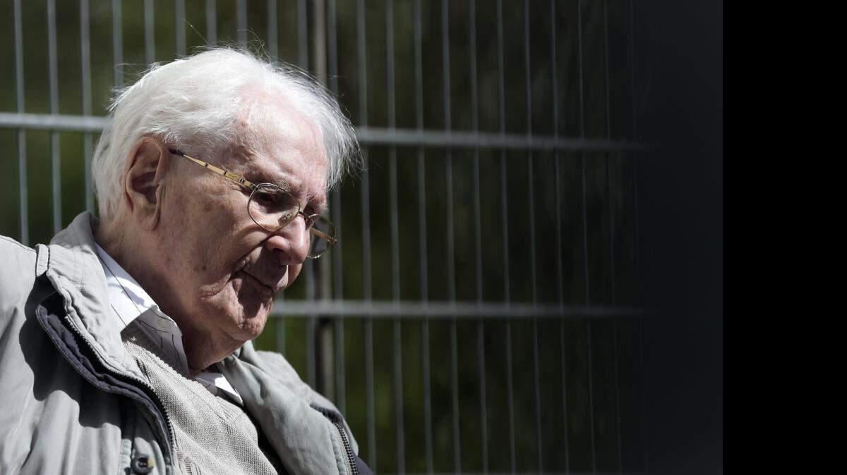 
Former S.S. guard Oskar Groening sits in ths sun during the noon break of the trial against him in Lueneburg, Germany, Tuesday, April 21, 2015. Groening, 93, faces 300,000 counts of accessory to murder at the trial, which will test the argument that anyone who served as a guard at a Nazi death camp was complicit in what happened there. 
