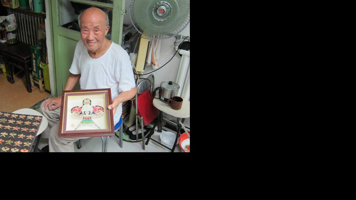 Before his eyesight started to fade, Fei Baoling, 86, was known for his intricately detailed swallow kites, a speciality of Beijing kite makers. He is pictured here with one of his swallow kites at his home in Beijing on Aug. 7, 2014.