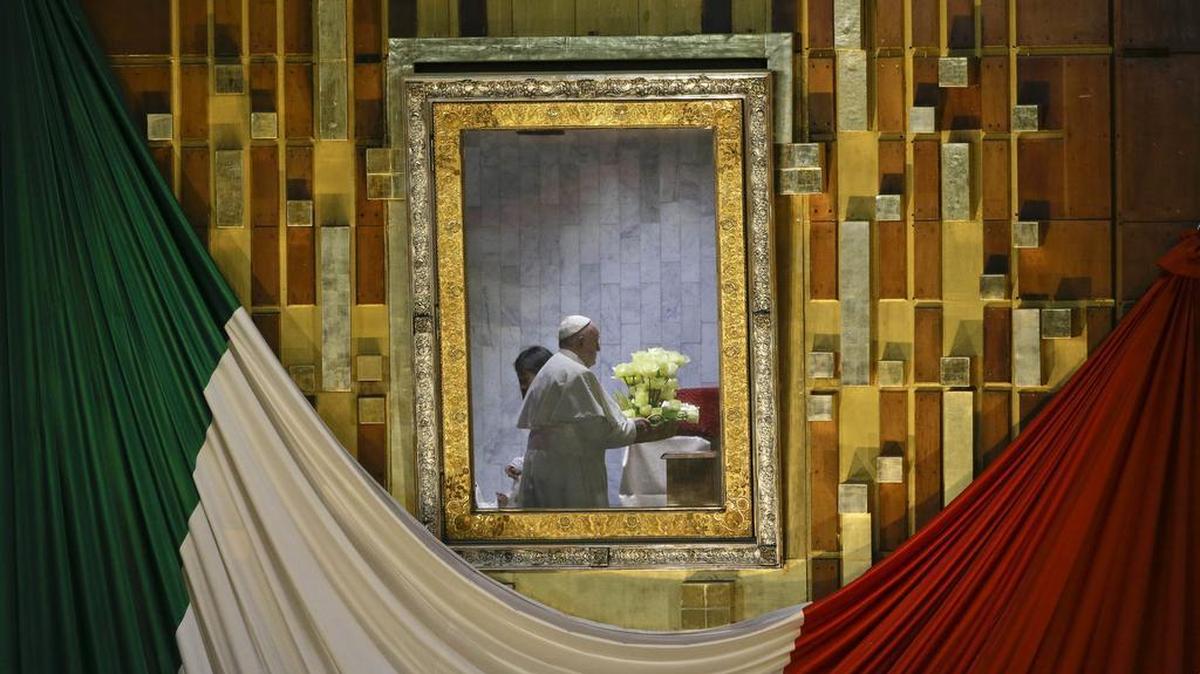 Pope Francis, reflected in the frame that holds the image of the Virgin of Guadalupe, holds a bouquet of flowers as he prays to her inside the Basilica built in her honor in Mexico City, Feb. 13, 2016. The pontiff's five-day visit included a prayer before the Virgin of Guadalupe shrine, the largest and most important Marian shrine in the world and one that is particularly important to the first Latin American pope.