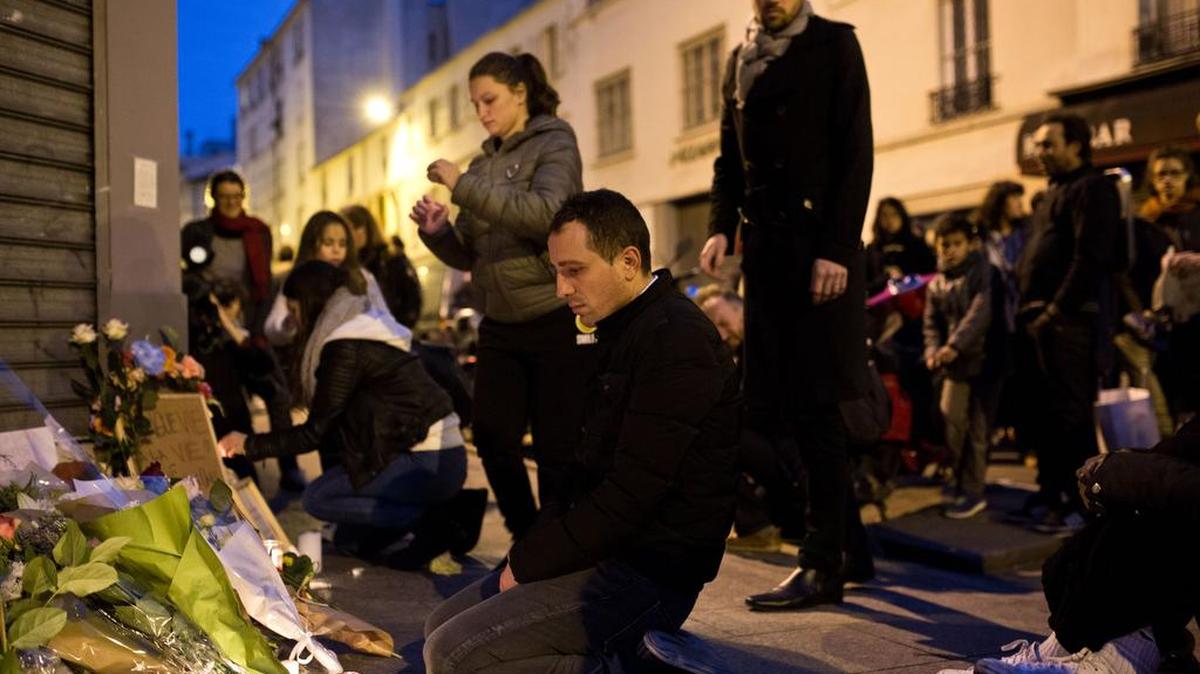 People leave flowers and signs at the Petit Cambodge, a restaurant where 12 people died during Friday's attacks in Paris.