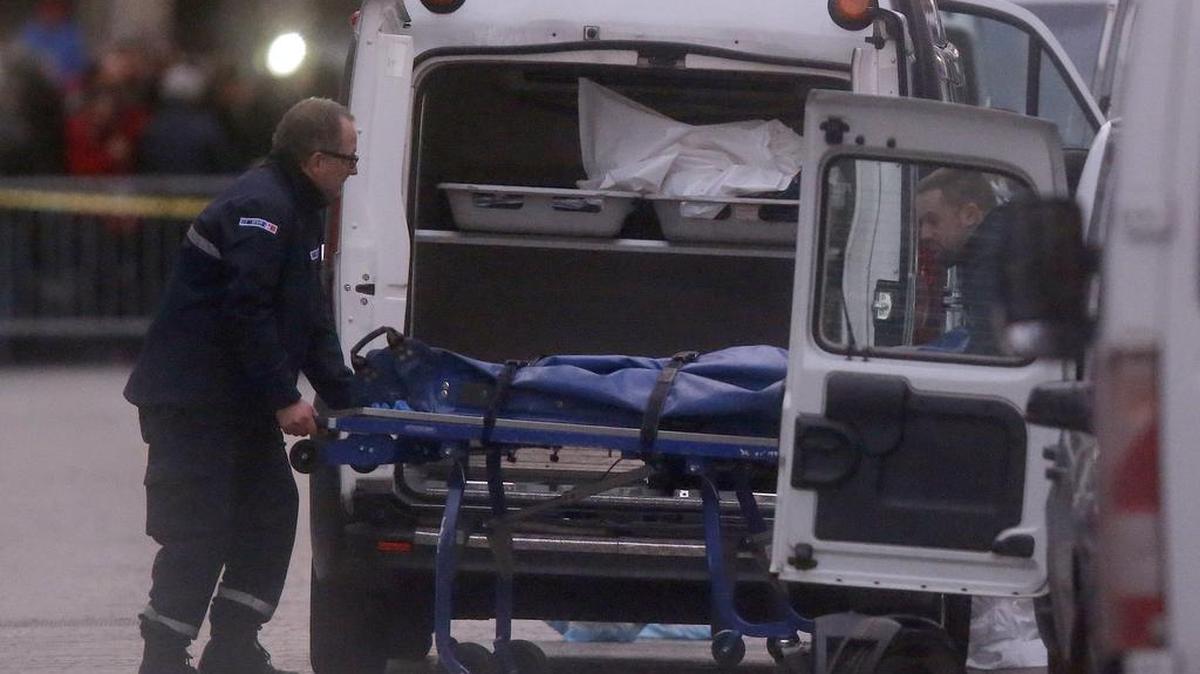 Two men carry a stretcher with a dead body into a hearse after an intervention of security forces against a group of extremists in Saint-Denis, near Paris, Wednesday, Nov. 18, 2015. A woman wearing an explosive suicide vest blew herself up Wednesday as heavily armed police tried to storm a suburban Paris apartment where the suspected mastermind of last week's attacks was believed to be holed up, police said.