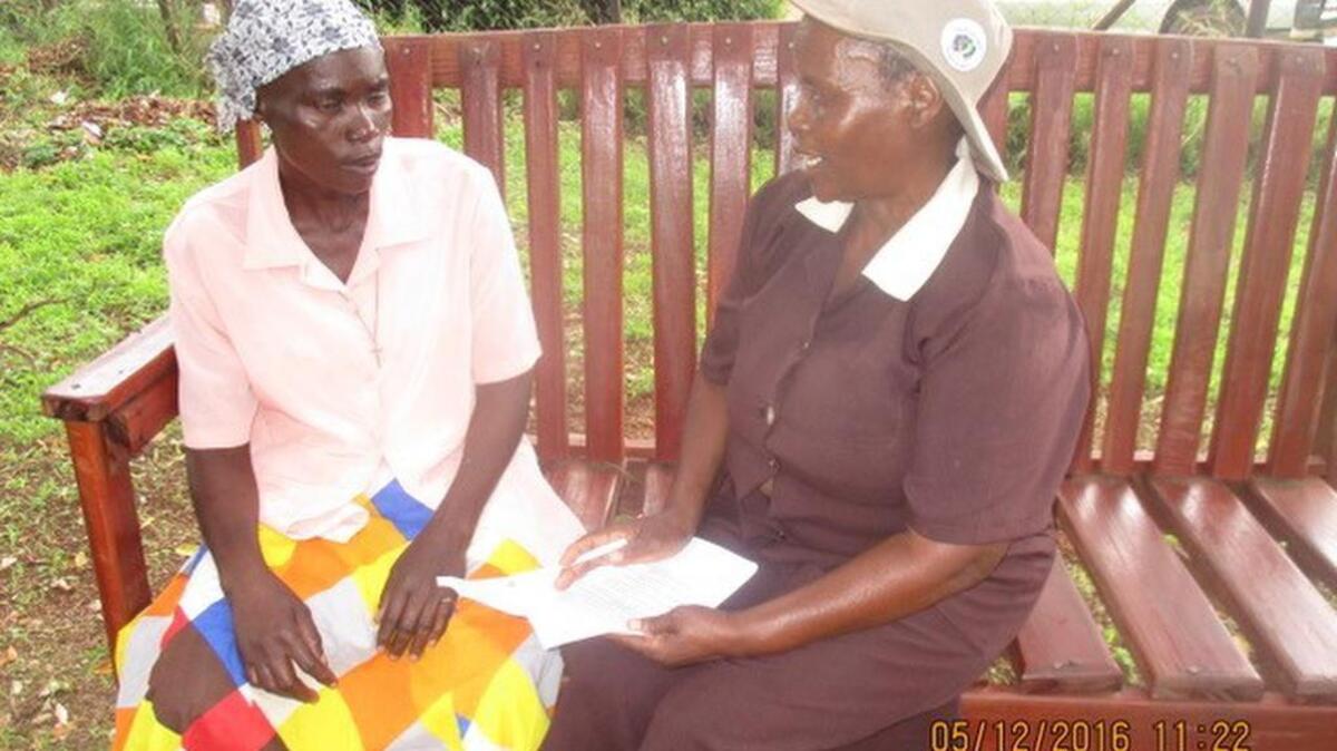 A woman speaks with a "grandmother" as part of Zimbabwe's Friendship Bench program.