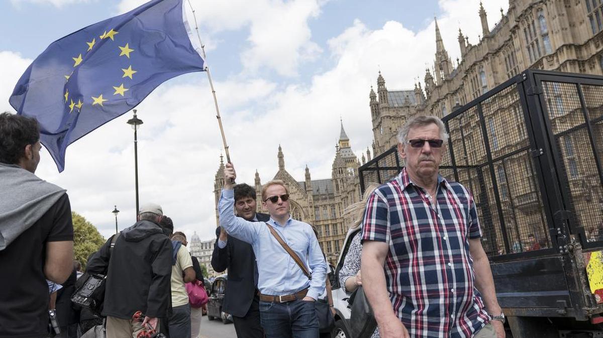 A man carries a European Union flag in front of the Houses of Parliament on June 24, 2016 in London, the day after Britain voted to leave the European Union.