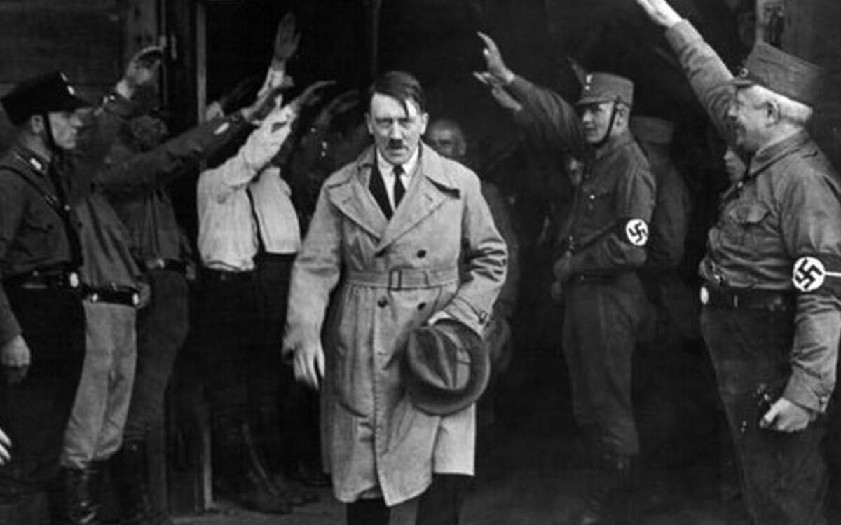 In this Dec. 5, 1931 file photo, Adolf Hitler, leader of the National Socialists, is saluted as he leaves the party's Munich headquarters.