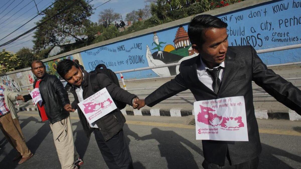 Nepalese people form a human chain during a protest in Kathmandu, Nepal, against a blockade on Monday. The Madhesi ethnic group has imposed a general strike in much of southern Nepal and blocked a key border point with India, causing a shortage of fuel and other goods in Nepal. People of Nepal also accuse India of imposing an “undeclared blockade,” which India denies.