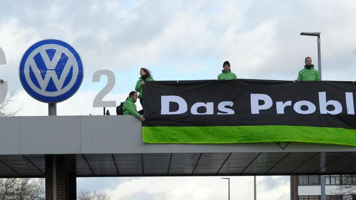 Greenpeace activists stand with ‘CO2’ formed with the VW logo and a banner that reads 'the problem' above the Volkswagen factory gate in Wolfsburg, Germany on Monday.