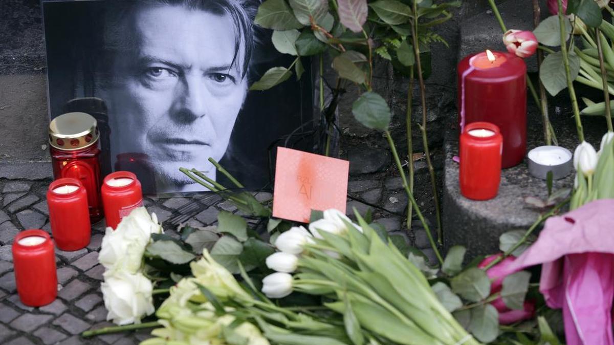 Flowers and a portrait are placed in front of the apartment building where David Bowie once lived in Berlin, Germany, Jan. 11, 2016.
