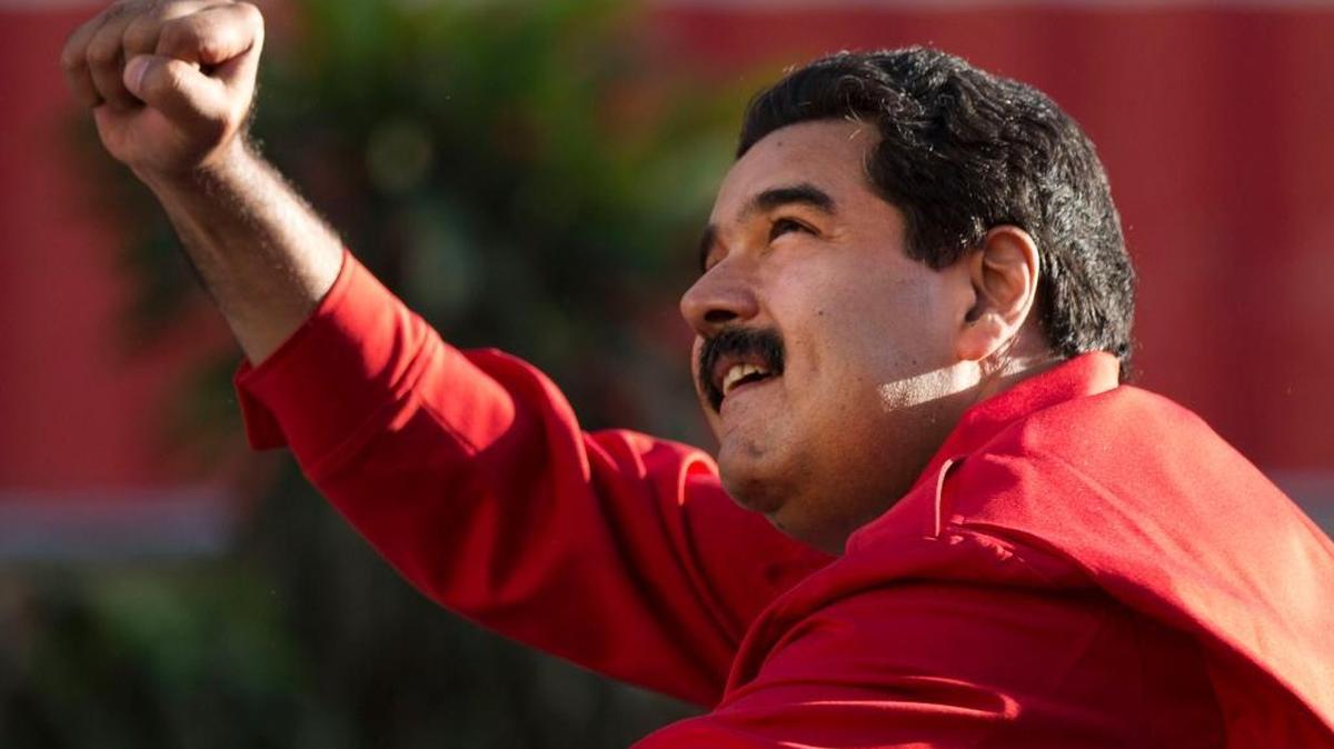 In this Dec. 1, 2015, photo, Venezuela’s President Nicolas Maduro gestures to supporters from the top of a car after the inauguration of a cable car public transportation system, in the popular neighborhood of Petare, in Caracas, Venezuela.