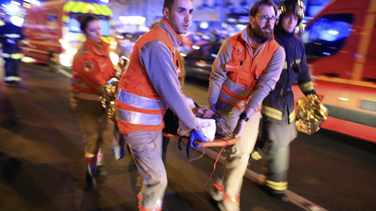 A woman is evacuated from the Bataclan theater, one of the sites of the terrorist attacks in Paris, Nov. 13, 2015.