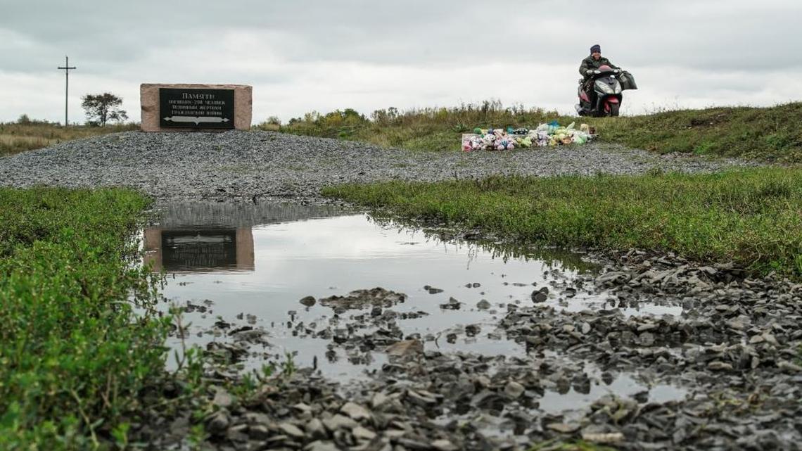 A woman rides her motorbike past the crash site of the Malaysia Airlines Flight 17, near the village of Hrabove, eastern Ukraine, Wednesday, Sept. 28, 2016. Dutch-led criminal investigators said Wednesday they have solid evidence that a Malaysian jet was shot down by a Buk missile moved into eastern Ukraine from Russia.