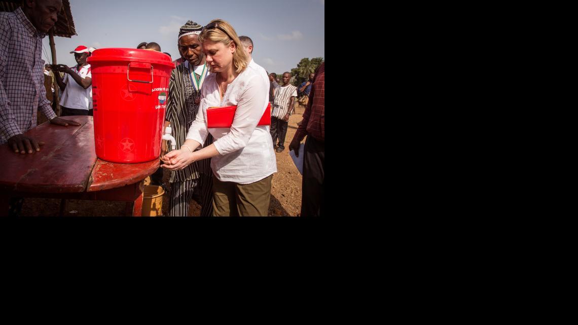 
British International Development Secretary Justine Greening washes her hands with chlorinated water as part of the Ebola virus decontamination process during her Ebola virus fact finding visit in the town of Kambia, Sierra Leone, Friday, Feb. 27, 2015. Greening visit in Monrovia yesterday is followed by an official visit to the Kambia district forming part of her Ebola virus campaign. 
