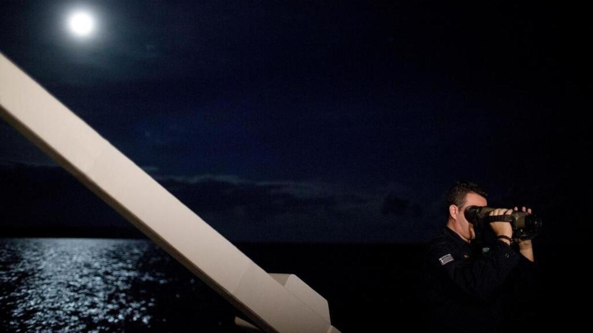 A Greek Coast Guard officer looks through night vision binoculars Wednesday during a patrol at the Aegean sea near the Greek island of Chios. Greek coast guard patrol vessels and lifeboats reinforced by the European Union’s border agency Frontex ply the waters of the eastern Aegean Sea along the frontier with Turkey, on the lookout for people being smuggled onto Greek islands, the frontline of Europe’s massive refugee crisis.
