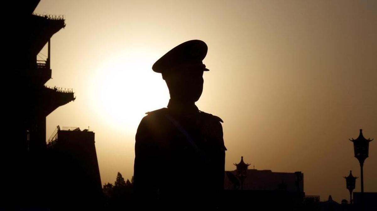 
The sun rises behind a paramilitary police officer standing guard outside Tiananmen Square ahead of the closing session of the third session of the 12th National People’s Congress in Beijing in March. 
