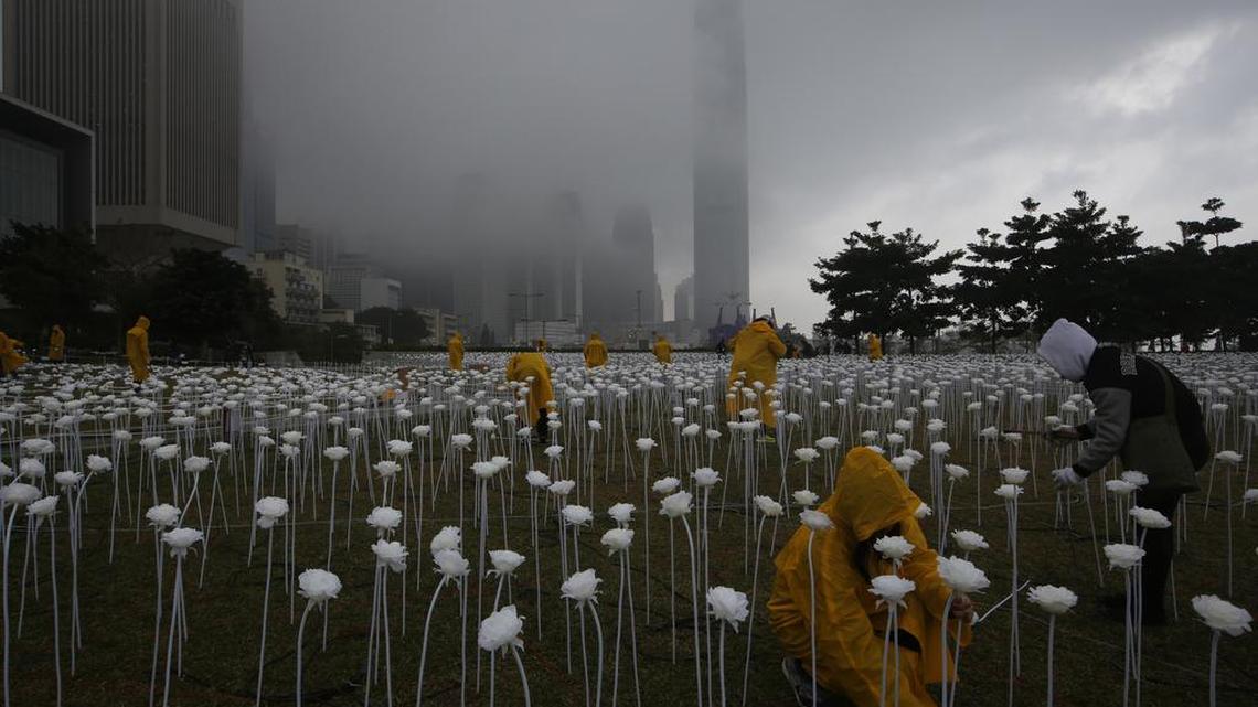 Workers place LED lights roses at the “Light Rose Garden”, against the backdrop of the Central, Hong Kong’s business district Feb. 12, 2016.