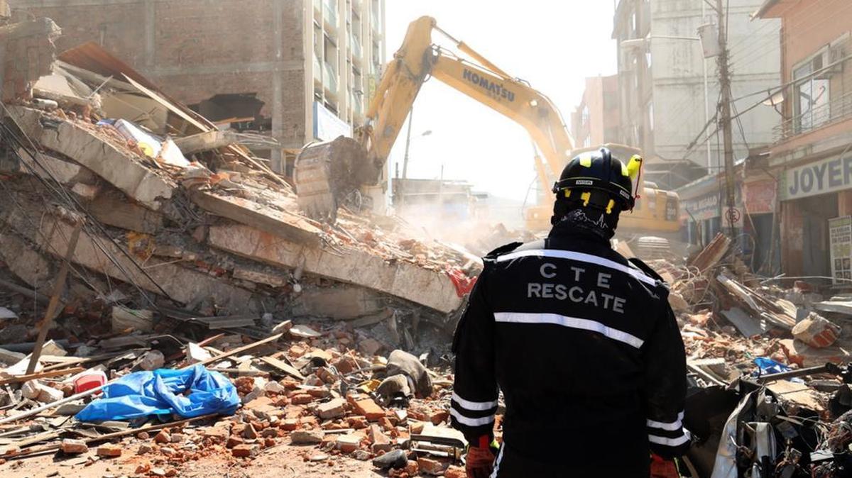 A rescue worker looks as heavy machinery removes the debris of a collapsed building in Portoviejo, Ecuador, on Sunday April 17, 2016. A magnitude-7.8 quake, the strongest since 1979, hit Ecuador flattening buildings, buckling highways along its Pacific coast and killing hundreds.