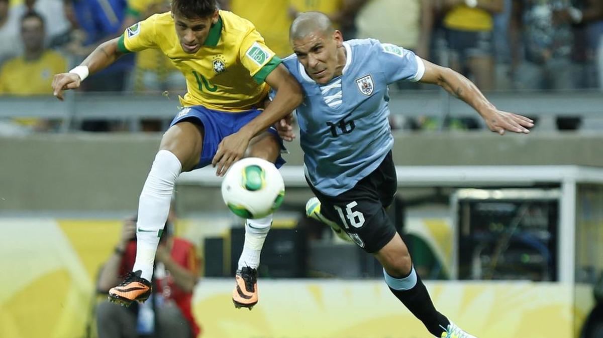 Brazil's Neymar, left, and Uruguay's Maximiliano Pereira challenge for the ball during the soccer Confederations Cup semifinal match between Brazil and Uruguay at the Mineirao stadium in Belo Horizonte, Brazil, June 26, 2013.