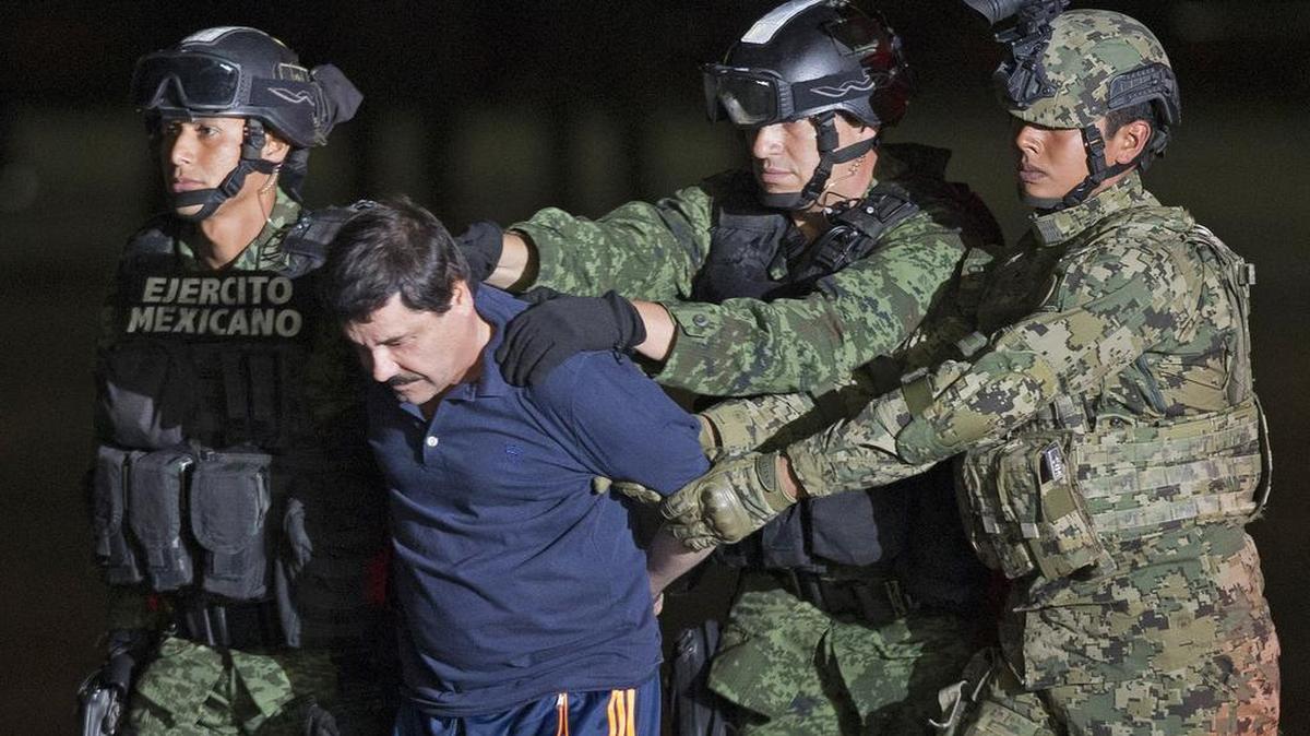 Mexican army soldiers escort drug lord Joaquin "El Chapo" Guzman to a helicopter to be transported to a maximum security prison at Mexico’s Attorney General’s hangar, in Mexico City on Jan. 8, 2016.