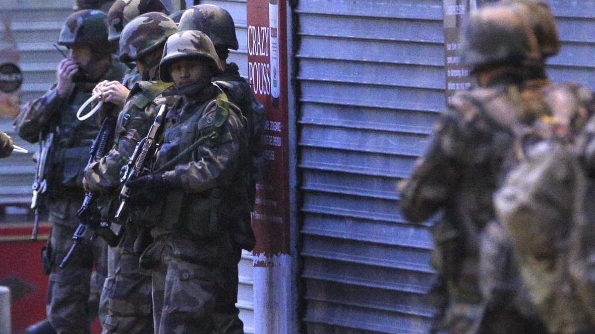 Soldiers operate in St. Denis, a northern suburb of Paris, Wednesday, Nov. 18, 2015. The Belgian jihadi suspected of masterminding deadly attacks in Paris was killed in a police raid on a suburban apartment building, the city prosecutor’s office announced Thursday.
