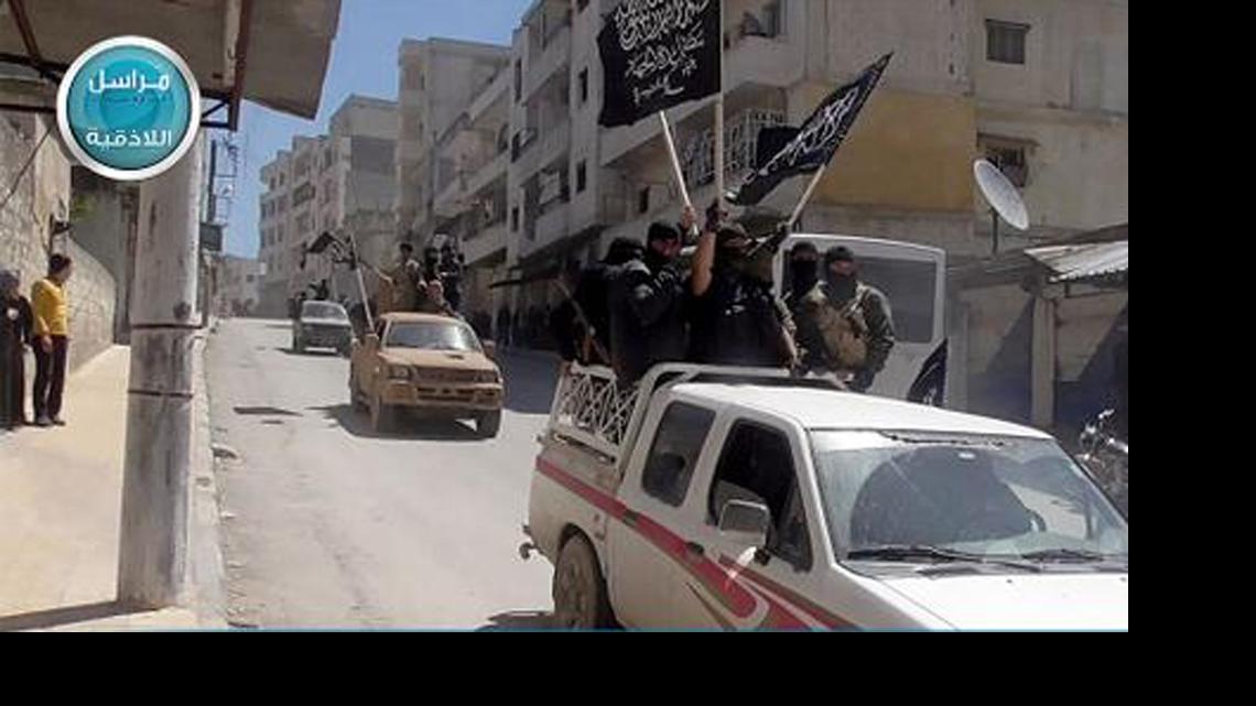 
This image posted on the Twitter page of Syria's al-Qaida-linked Nusra Front on Saturday April 25, 2015, which is consistent with AP reporting, shows Nusra Front fighters standing on their vehicles and waving their group's flags as they tour the streets of Jisr al-Shughour, Idlib province, Syria. 
