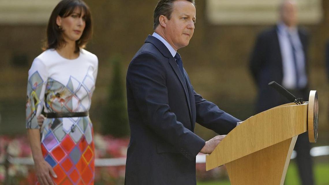 Britain's Prime Minister David Cameron speaks outside 10 Downing Street, London as his wife Samantha looks on Friday, June 24, 2016. Cameron says he will resign by the time of the party conference in the fall after Britain voted to leave the European Union after a bitterly divisive referendum campaign, according to tallies of official results Friday.