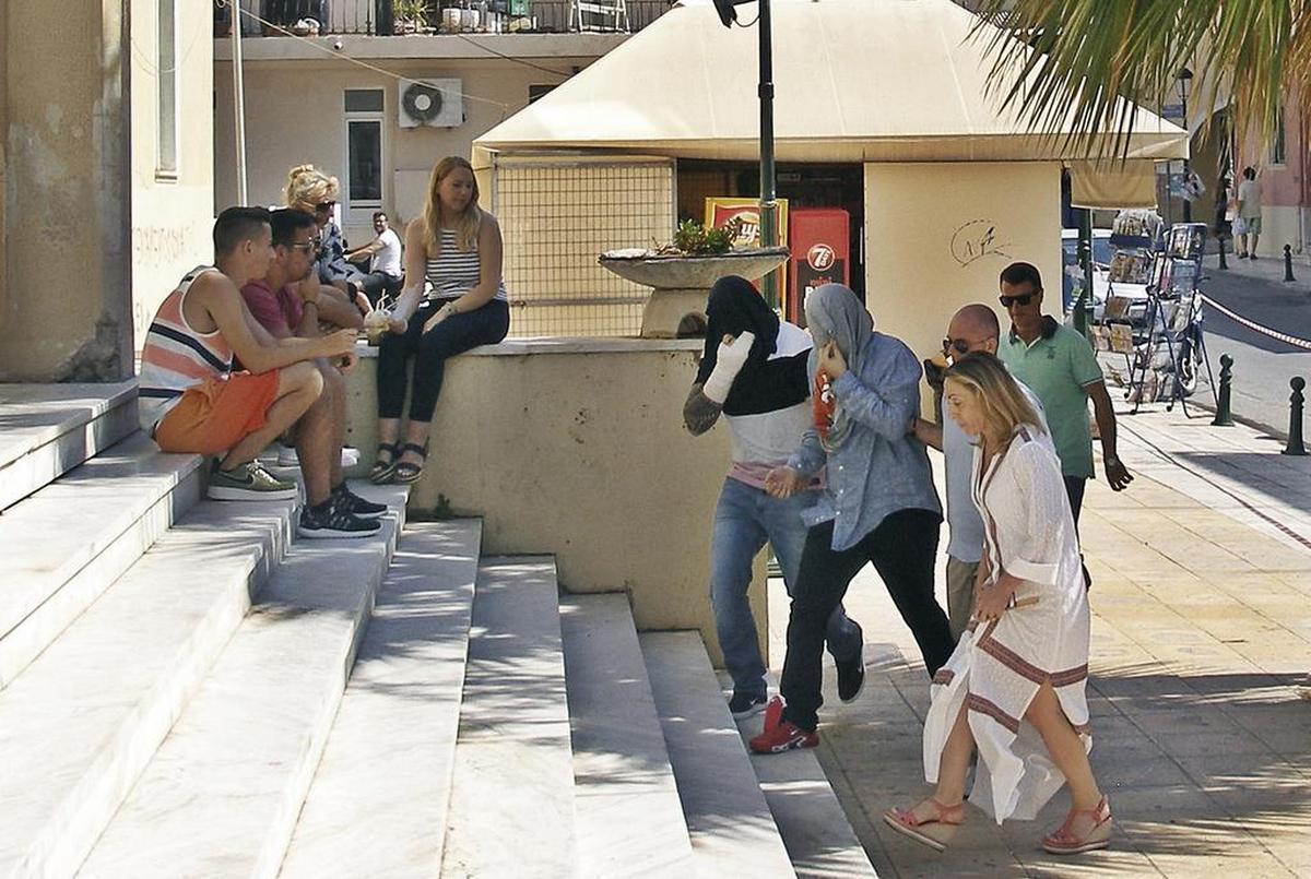 In this Saturday, July 8, 2017 photo, Suspects are led into court, Saturday, July 8, 2017, in Zakynthos, Greece. Eight suspects charged with involvement in the fatal beating of a 22-year-old American tourist.