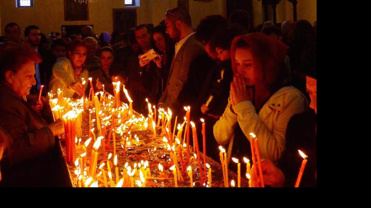 
Worshippers light candles at Easter Sunday service in Armenia's main cathedral. It is in this Cathedral on April 23, 2015, that the Armenian Apostolic Church canonized as a group the victims of the 1915-1917 deportations and massacres - at least one million people, according to historians. 
