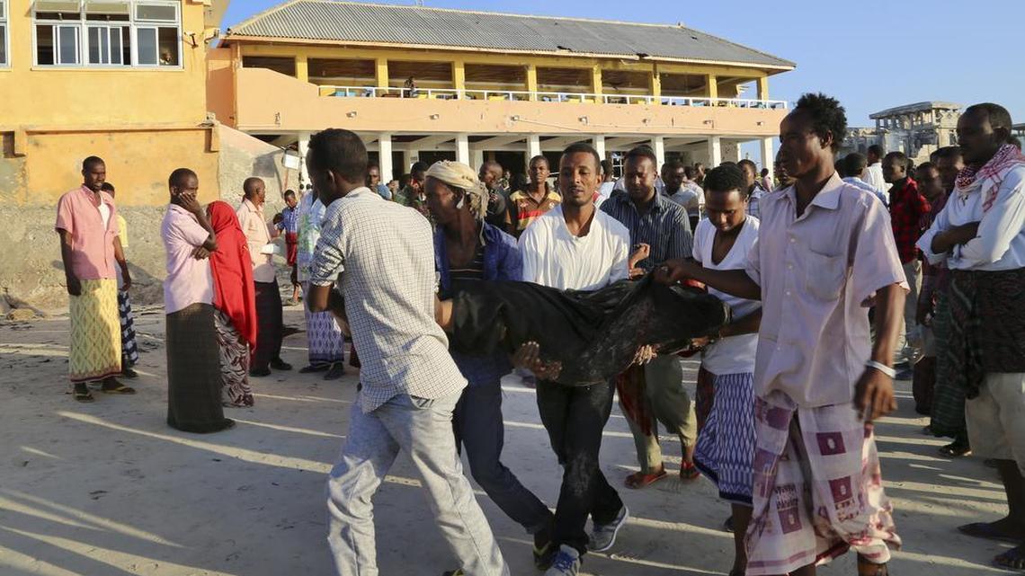 People carry away a dead body from the beach following an overnight attack on a beachfront restaurant in Mogadishu, Somalia, on Friday. Somalia's security forces ended a deadly siege of a beachfront restaurant in the capital, with many killed in the attack, a police official said Friday.