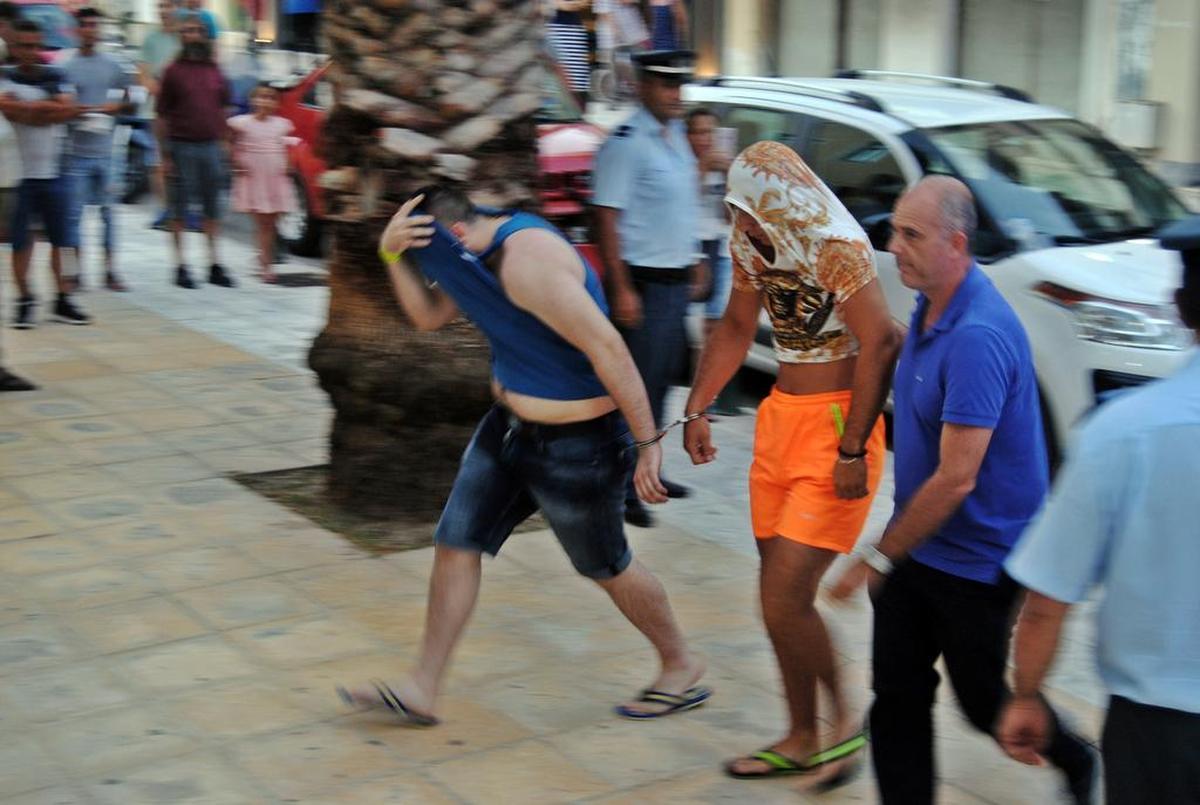 In this Saturday, July 8, 2017 photo, Suspects are led into court, Saturday, July 8, 2017, in Zakynthos, Greece. Eight suspects charged with involvement in the fatal beating of a 22-year-old American tourist.