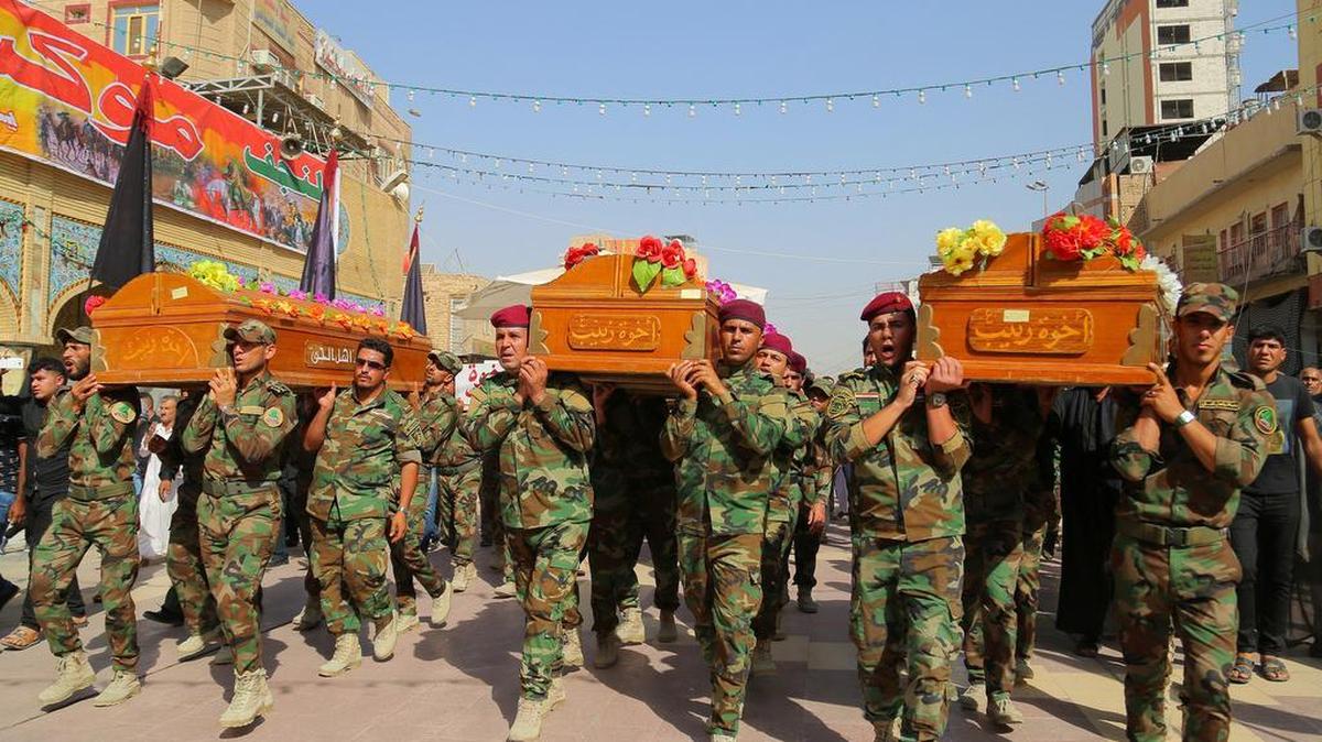Members of the Shiite group Asaib Ahl al-Haq, or "League of the Righteous," carry the coffins of seven of their colleagues who were killed while supporting Iraqi security forces battling Islamic State group in Beiji, according to his family, during his funeral in Najaf, 100 miles (160 kilometers) south of Baghdad, Sunday, Oct. 18, 2015.