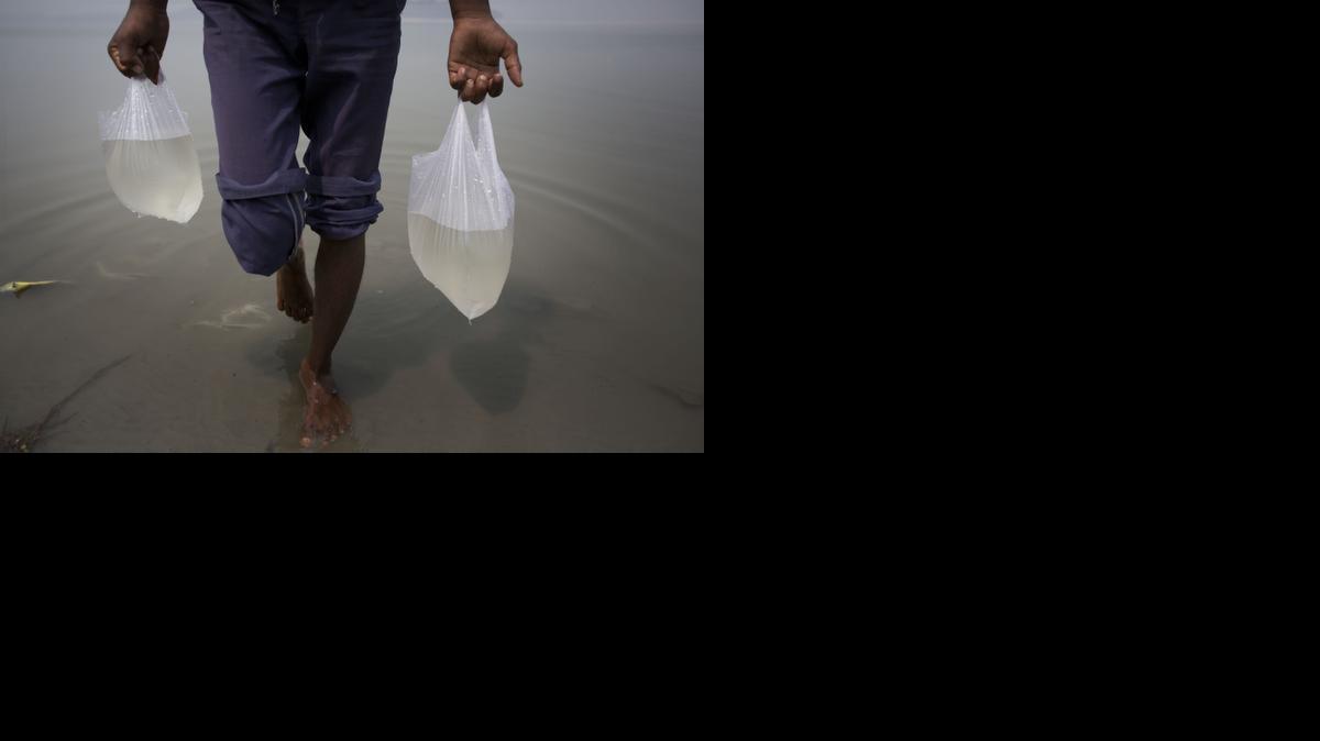 
A vegetable seller carries water from river Brahmaputra before spraying them on vegetables on World Water Day in Gauhati, India, Sunday, March 22, 2015. The U.N. warns that the world could suffer a 40 percent shortfall in water by 2030 unless countries dramatically change their use of the resource. 
