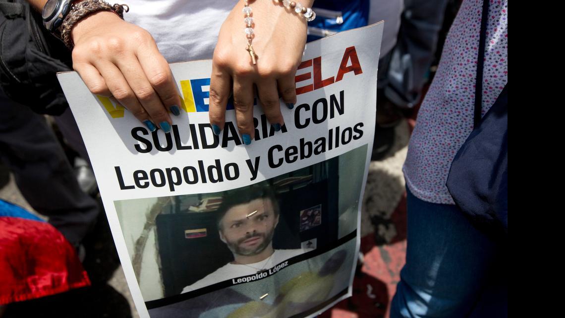 
A supporter of jailed opposition leader Leopoldo López holds a poster of him and fellow prisoner Daniel Ceballos during an anti-government protest in Caracas, Venezuela, on Saturday. The poster reads in Spanish: "Solidarity with Leopoldo and Ceballos." 
