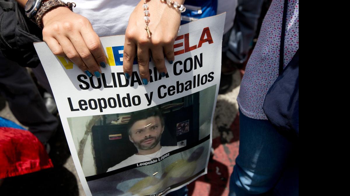 
A supporter of jailed opposition leader Leopoldo López holds a poster of him and fellow prisoner Daniel Ceballos during an anti-government protest in Caracas, Venezuela, on Saturday. The poster reads in Spanish: "Solidarity with Leopoldo and Ceballos." 
