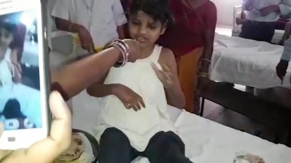 A young Indian girl sits on a bed at a hospital in this image taken from video in Bahraich, northern India, on Thursday, April 6, 2017. Indian police are reviewing reports of missing children from recent years to try to identify the girl who was found in a forest with a group of monkeys.