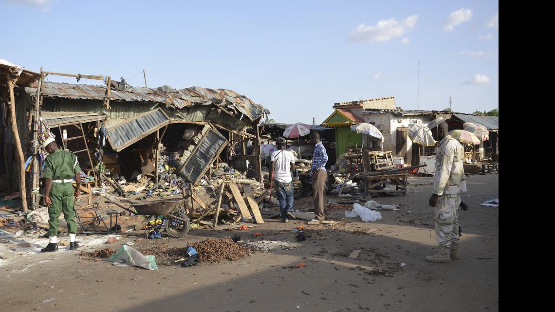 
People gather at the site of a suicide bomb attack at a market in Maiduguri, Nigeria, on June 22, 2015. A teenage girl strapped with explosives ran away from a crowded mosque this week, killing only herself and cementing suspicions that Boko Haram is using unwilling captives in its terror campaign in northeast Nigeria. The girl took off after her companion blew up in an explosion that killed 30 people on Monday in Maiduguri, the biggest city in northeast Nigeria, witnesses and a mortuary worker said.
